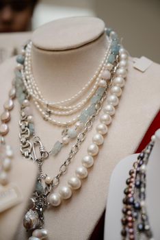 Shop window with necklaces and jewelry. Custome jewelry on display.Variety of colorful necklaces, bracelets, earrings, rings in window of costume jewelry store