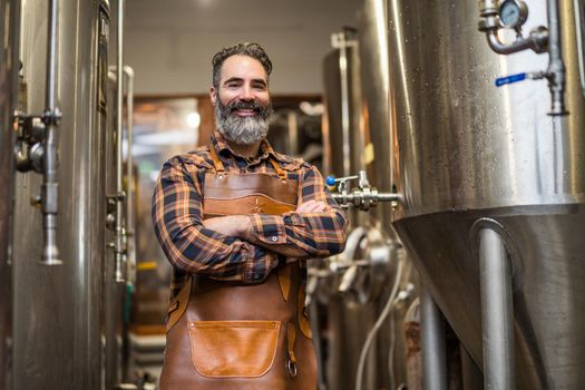 Portrait of man who is working at craft beer factory. Small family business, production of craft beer.