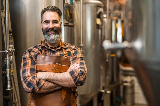 Portrait of man who is working at craft beer factory. Small family business, production of craft beer.