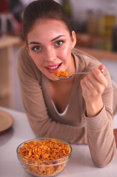 Smiling woman having breakfast in kitchen interior