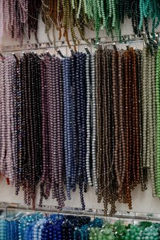 Shop window with necklaces and jewelry. Custome jewelry on display.Variety of colorful necklaces, bracelets, earrings, rings in window of costume jewelry store