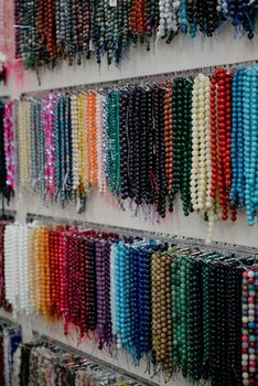 Shop window with necklaces and jewelry. Custome jewelry on display.Variety of colorful necklaces, bracelets, earrings, rings in window of costume jewelry store