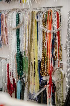 Shop window with necklaces and jewelry. Custome jewelry on display.Variety of colorful necklaces, bracelets, earrings, rings in window of costume jewelry store