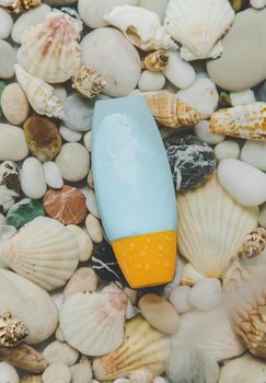 Sunscreen on the background of sea stones. Selective focus. Spa.