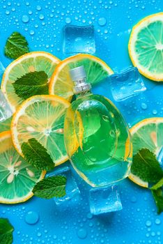 Perfume on a blue background with ice cubes and mint lemon. Selective focus. Spa.