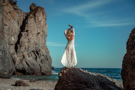 Middle aged woman looks good with blond hair, boho style in white long dress on the beach decorations on her neck and arms