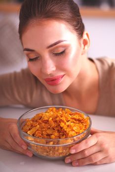 Smiling woman having breakfast in kitchen interior