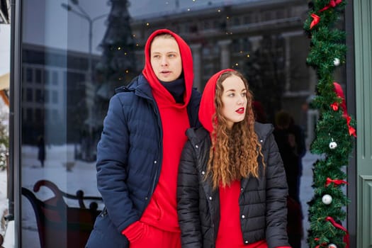 young happy family, a guy and a girl spend the day near the cafe, the guy hugs the girl