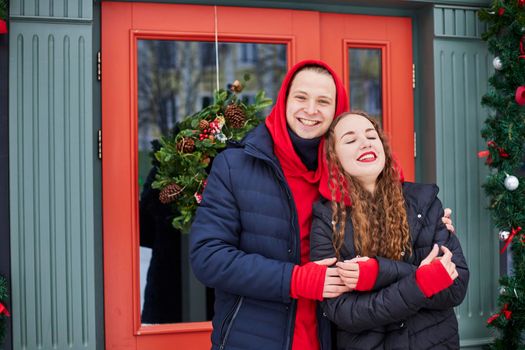 young happy family, a guy and a girl spend the day near the cafe, the guy hugs the girl