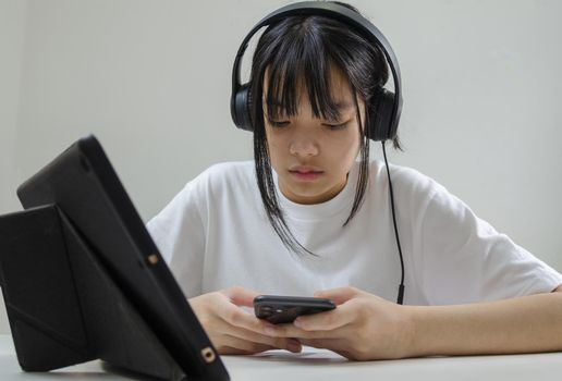girl wearing headphones studying online with computer laptop and listen to relaxing music or play internet social media at home.