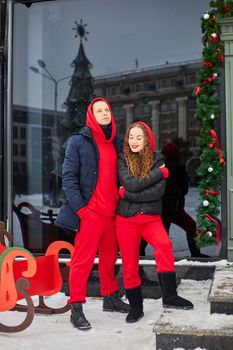 young happy family, a guy and a girl spend the day near the cafe, the guy hugs the girl