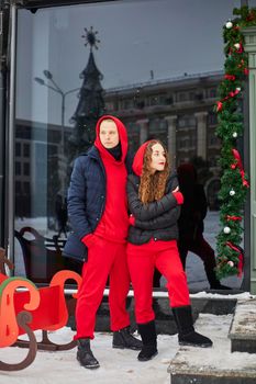 young happy family, a guy and a girl spend the day near the cafe, the guy hugs the girl