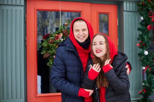 young happy family, a guy and a girl spend the day near the cafe, the guy hugs the girl