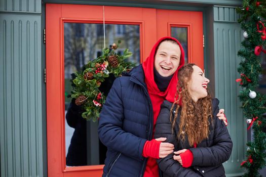 young happy family, a guy and a girl spend the day near the cafe, the guy hugs the girl