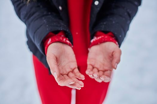 hands of a young woman, close-up, frozen from playing snowballs