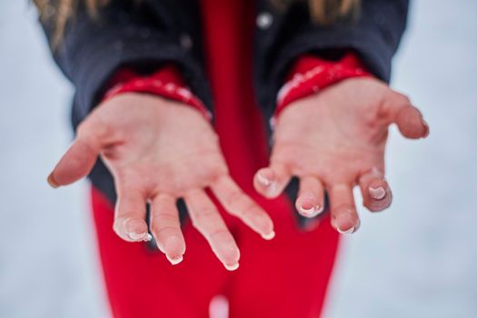 hands of a young woman, close-up, frozen from playing snowballs