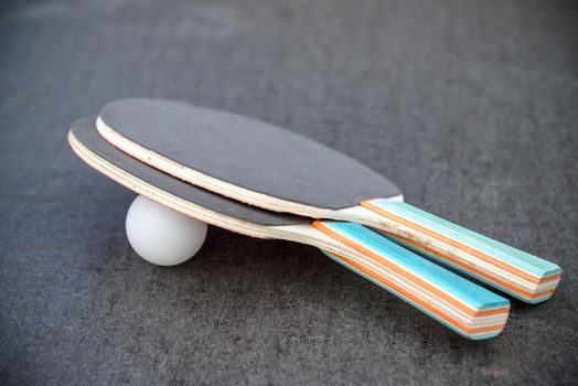 Two Tennis Rackets and one Ball on Table outdoors. Active leisure concept.