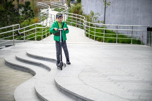 Happy family lifestyle and holiday concept. One little boy riding scooter, walking in city, street. Having fun alone.