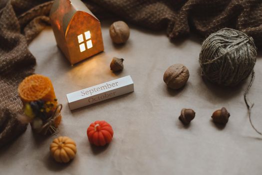 Autumn still life details in cozy home interior with a cup, candles, plaid. Hygge home decor. Halloween and Thanksgiving concept. Autumn banner