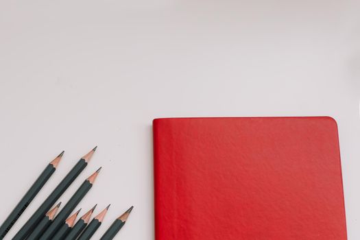 Back to school concept, school and office supplies, top view of notebook and pencils on white background, flat lay, copy space