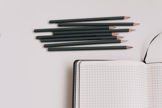Back to school concept, school and office supplies, top view of notebook and pencils on white background, flat lay, copy space