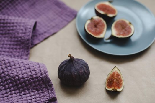 still life with ripe fresh figs and purple textiles on rustic background, flatlay, overhead view