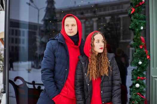 young happy family, a guy and a girl spend the day near the cafe, the guy hugs the girl