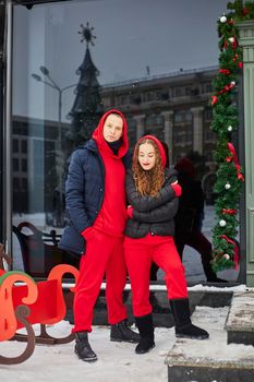 young happy family, a guy and a girl spend the day near the cafe, the guy hugs the girl