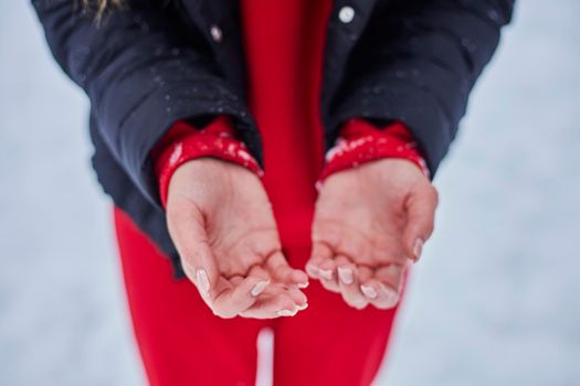 hands of a young woman, close-up, frozen from playing snowballs