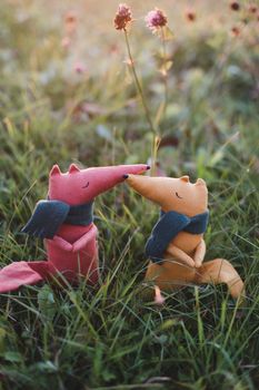 Cute little handmade toy fox in green grass. Childhood, baby, holiday, people, hobby, emotions concepts. High quality photo