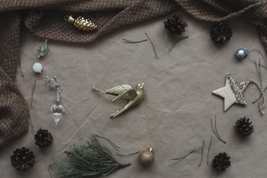 Christmas composition on craft paper background with gift box, fir branches, toys, copy space for your congratulations.