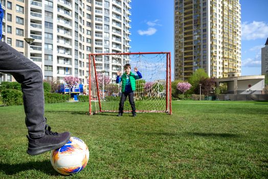 Little preschool boys friends playing soccer football on playground grass field outside. Happy authentic candid childhood lifestyle. Seasonal summer outdoor activity with ball for kids.
