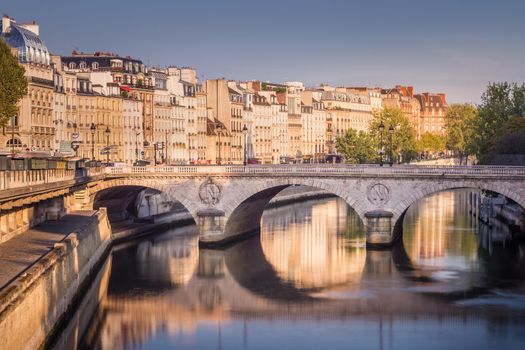 Pont Neuf and peaceful Seine river in Paris at clear sunrise