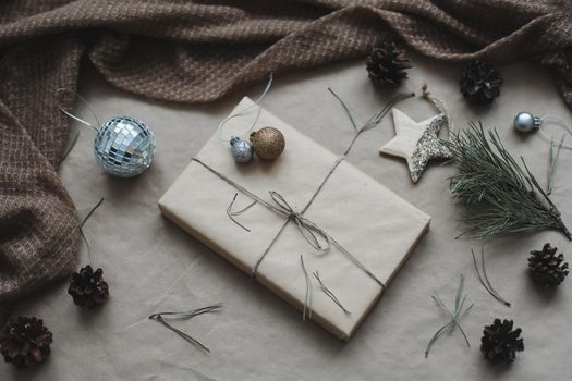 Christmas composition on craft paper background with gift box, fir branches, toys, copy space for your congratulations.