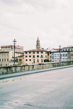 Asphalt road with lanterns against the backdrop of old houses in Florence. High quality photo