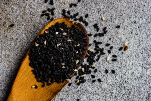 Overhead view of vintage wooden spoon with black sesame seeds