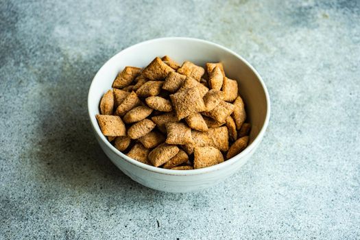 Bowl with traditional cereal breakfast balls on concrete table