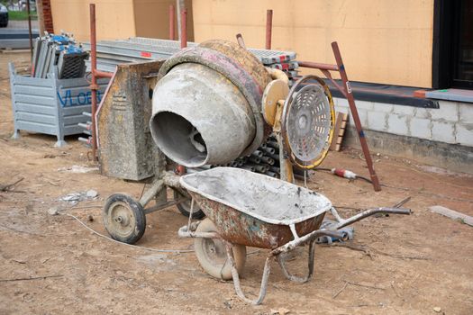 dirty concrete mixer near the construction of a house on the ground building materials, renovation. High quality photo