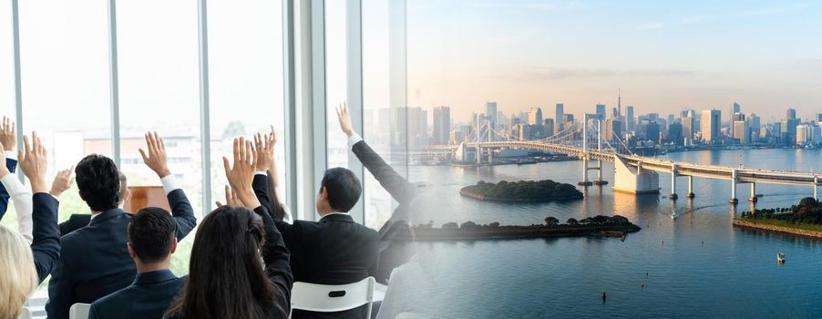 Group of business people meeting in a seminar conference widen view . Audience listening to instructor in employee education training session . Office worker community summit forum with speaker .