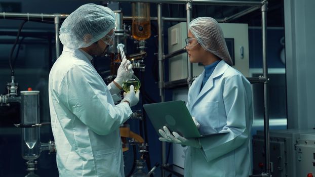 Two scientist in professional uniform working in laboratory for chemical and biomedical experiment