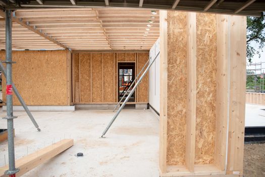 strong metal scaffolding at the construction site of a new house, the beginning of wooden structures around a metal frame. High quality photo