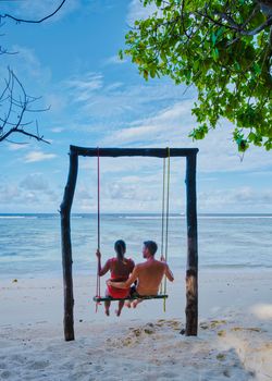 Anse Source d'Argent, La Digue Seychelles, a young couple of Caucasian men and Asian women on a tropical beach during a luxury vacation in Anse Source d'Argent, La Digue Seychelles