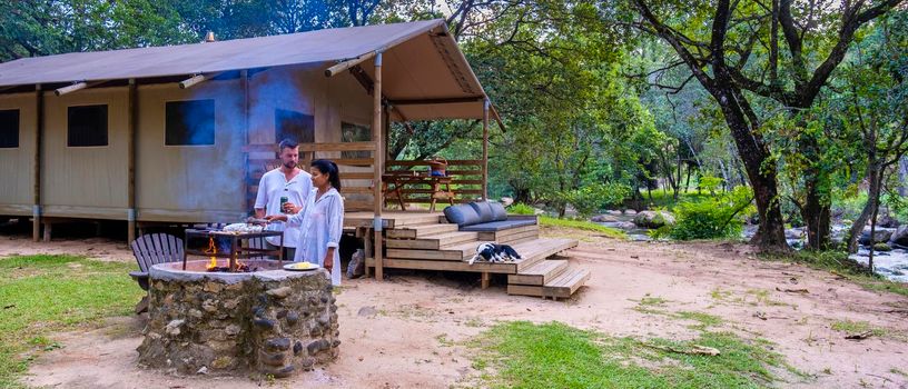 Budget Safari tent in South Africa for family vacations in nature, Safari tented camp in green forest bush nature. Asian women and European men camping