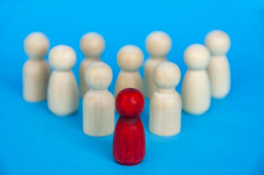 Wooden red doll leading the rest of wooden figure. Leadership and followers concept. Copy space