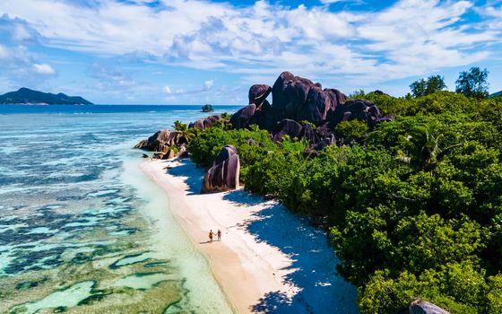 Anse Source d'Argent, La Digue Seychelles, a young couple of Caucasian men and Asian women on a tropical beach during a luxury vacation in Anse Source d'Argent, La Digue Seychelles