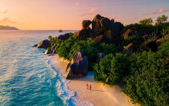 Anse Source d'Argent, La Digue Seychelles, a young couple of Caucasian men and Asian women on a tropical beach during a luxury vacation in Anse Source d'Argent, La Digue Seychelles