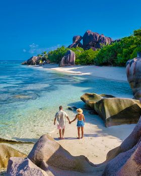 Anse Source d'Argent, La Digue Seychelles, a young couple of Caucasian men and Asian women on a tropical beach during a luxury vacation in Anse Source d'Argent, La Digue Seychelles