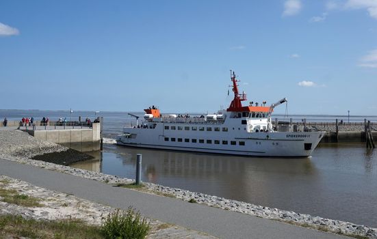 Neuharlingersiel, Germany - June 9 2020 - A ferry called Spiekeroog II on the Wadden Sea is entering the harbor of Neuharlingersiel in East Frisia, Germany. It has departed from the Wadden Island Spiekeroog.
