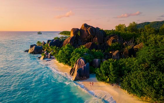 Anse Source d'Argent, La Digue Seychelles, a young couple of Caucasian men and Asian women on a tropical beach during a luxury vacation in Anse Source d'Argent, La Digue Seychelles