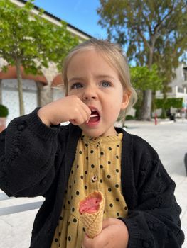 Little girl eats ice cream cone with a spatula. High quality photo